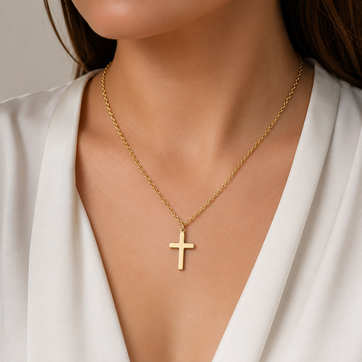 Woman wearing a gold-tone cross pendant necklace