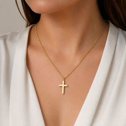 Woman wearing a gold-tone cross pendant necklace